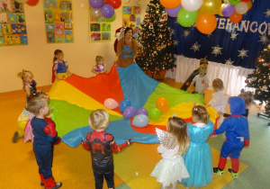 Dzieci podrzucają balony rozłożone na chuście animacyjnej.